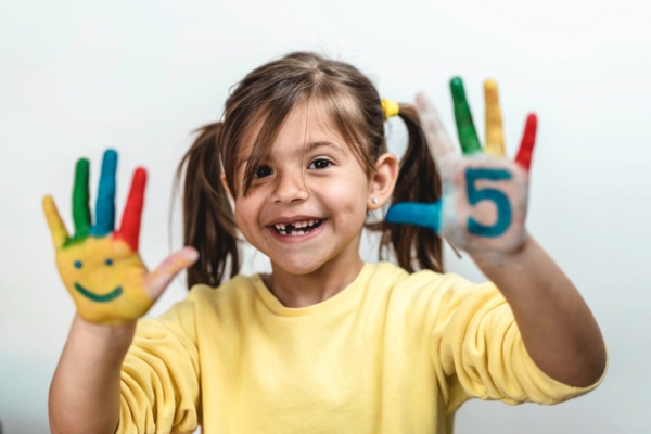 happy girl with number 5 painted on hand depicting Effective Ways to Improve Comfort